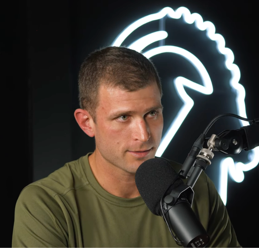 Kyle Layne speaking into a podcast microphone during a conversation.